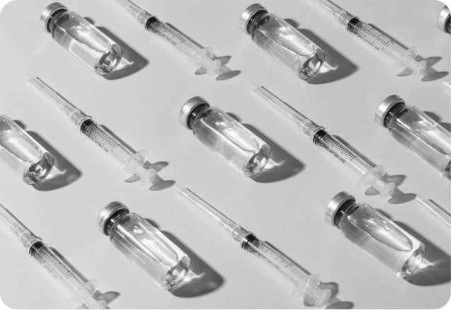 Zu sehen sind modern angeordnete Spritzen und Fläschchen für ästhetische Injektionen.