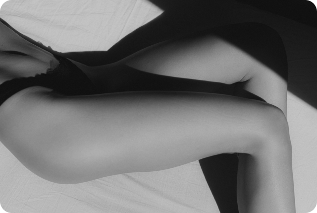 Zu sehen ist ein äestheischer Teilausschnitt in schwarz weiss einer Frau. Man sieht eine schlanke und perfekte Hüft- und Beinregion.